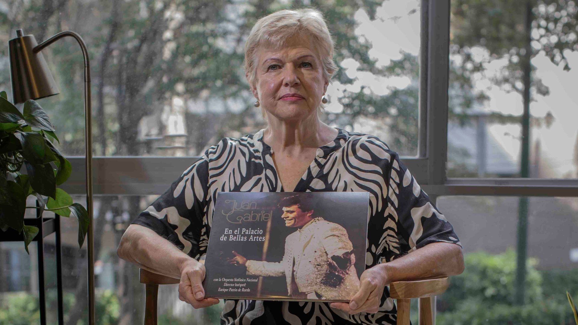 Una adulta mayor tiene una imagen de una imagen de Juan Gabriel.