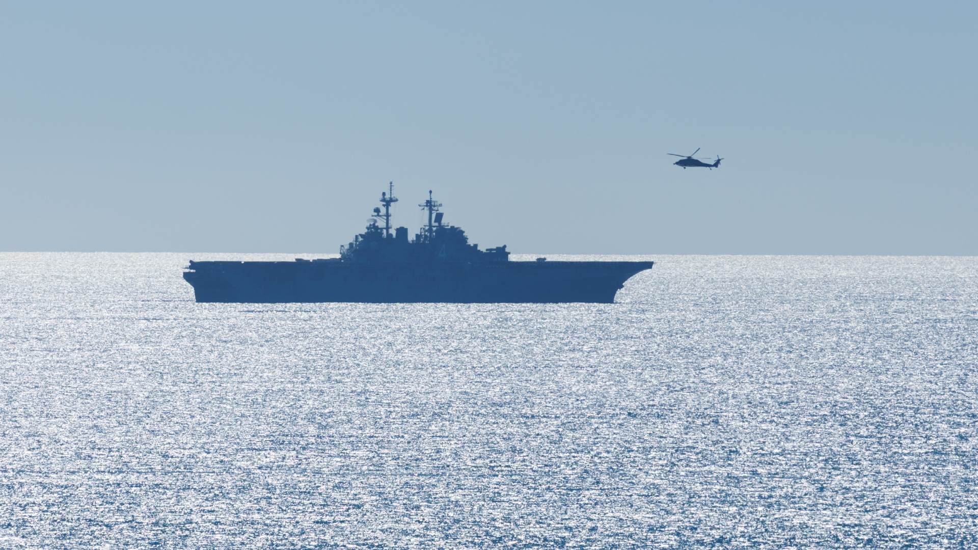 Un helicóptero se acerca a un barco de asalto, como parte de un entrenamiento frente a costas de California