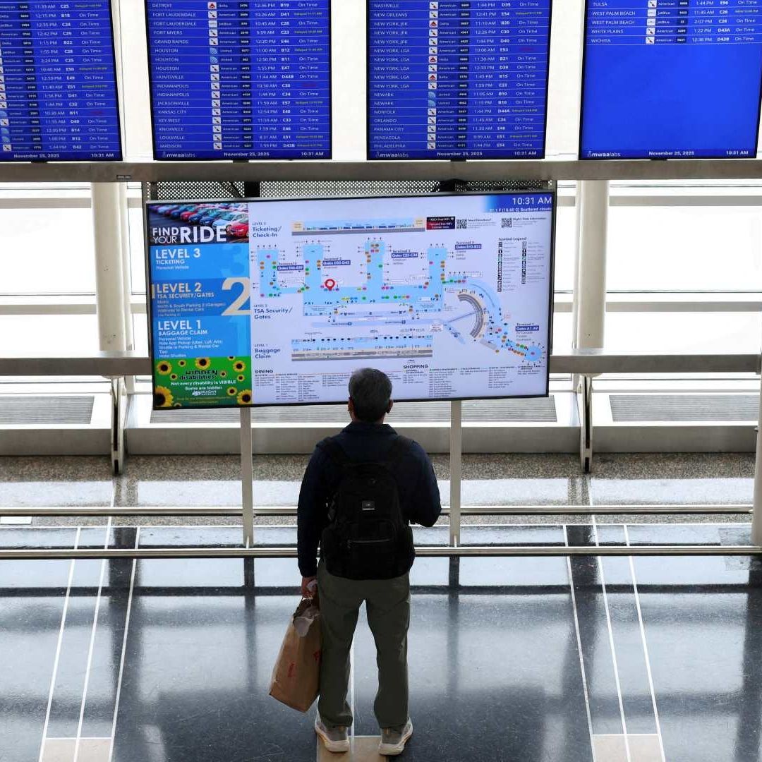 Pasajero mira panel de información de vuelos en el Aeropuerto Ronald Reagan de Washington, en noviembre 2025. Foto: Reuters