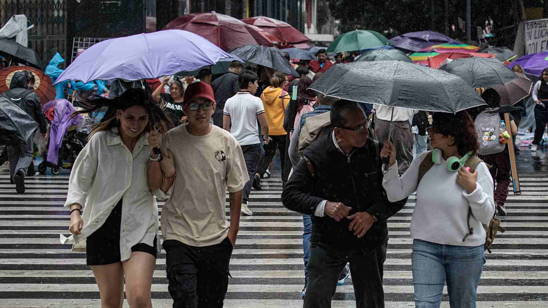 Personas se protegen de la lluvia en calles de la Ciudad de México.