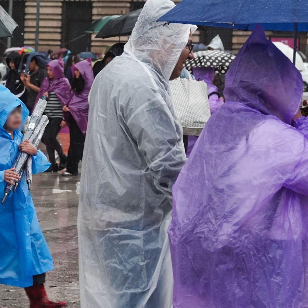 Personas se protegen de la lluvia en la Alameda Central, CDMX