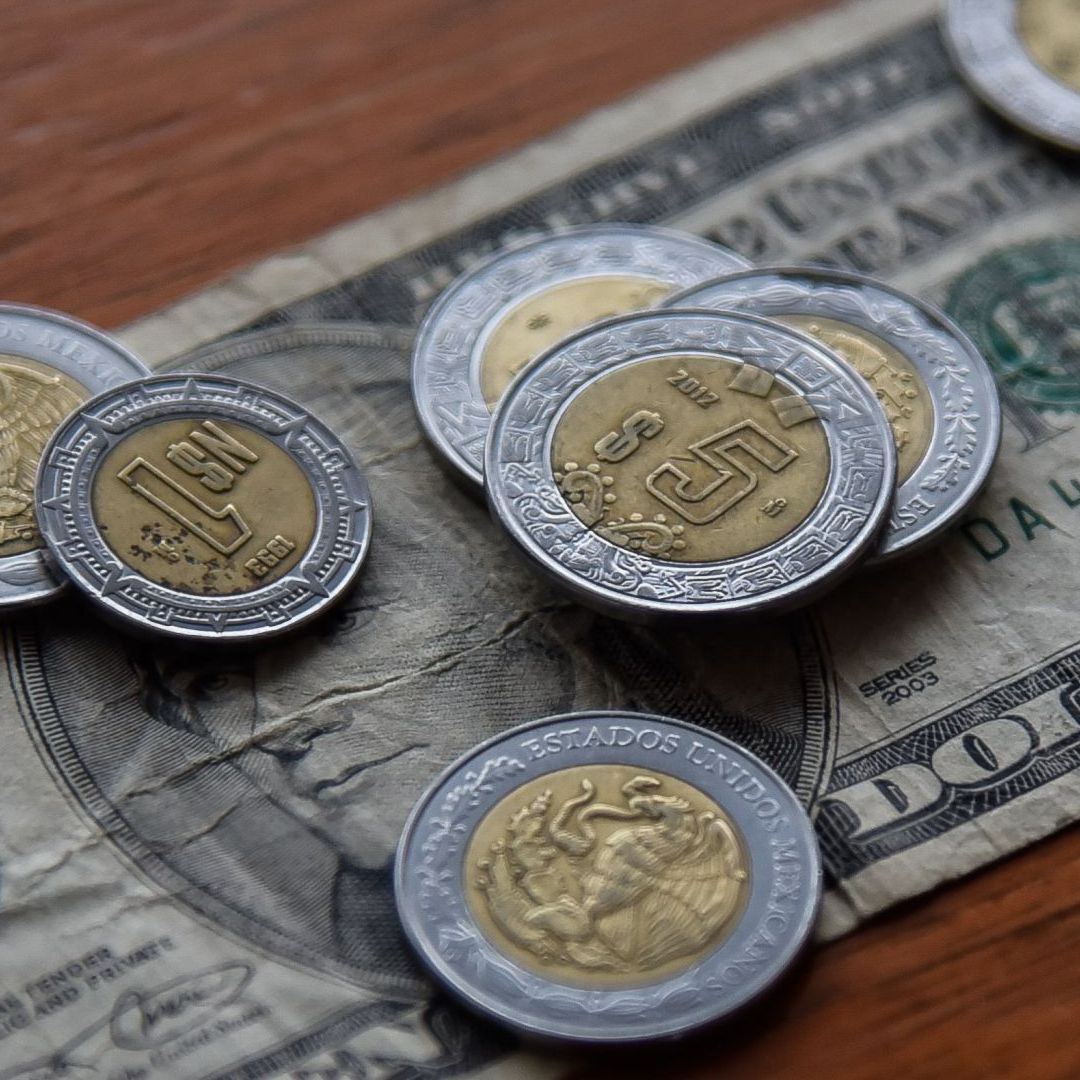 Monedas mexicanas y un billete estadounidense