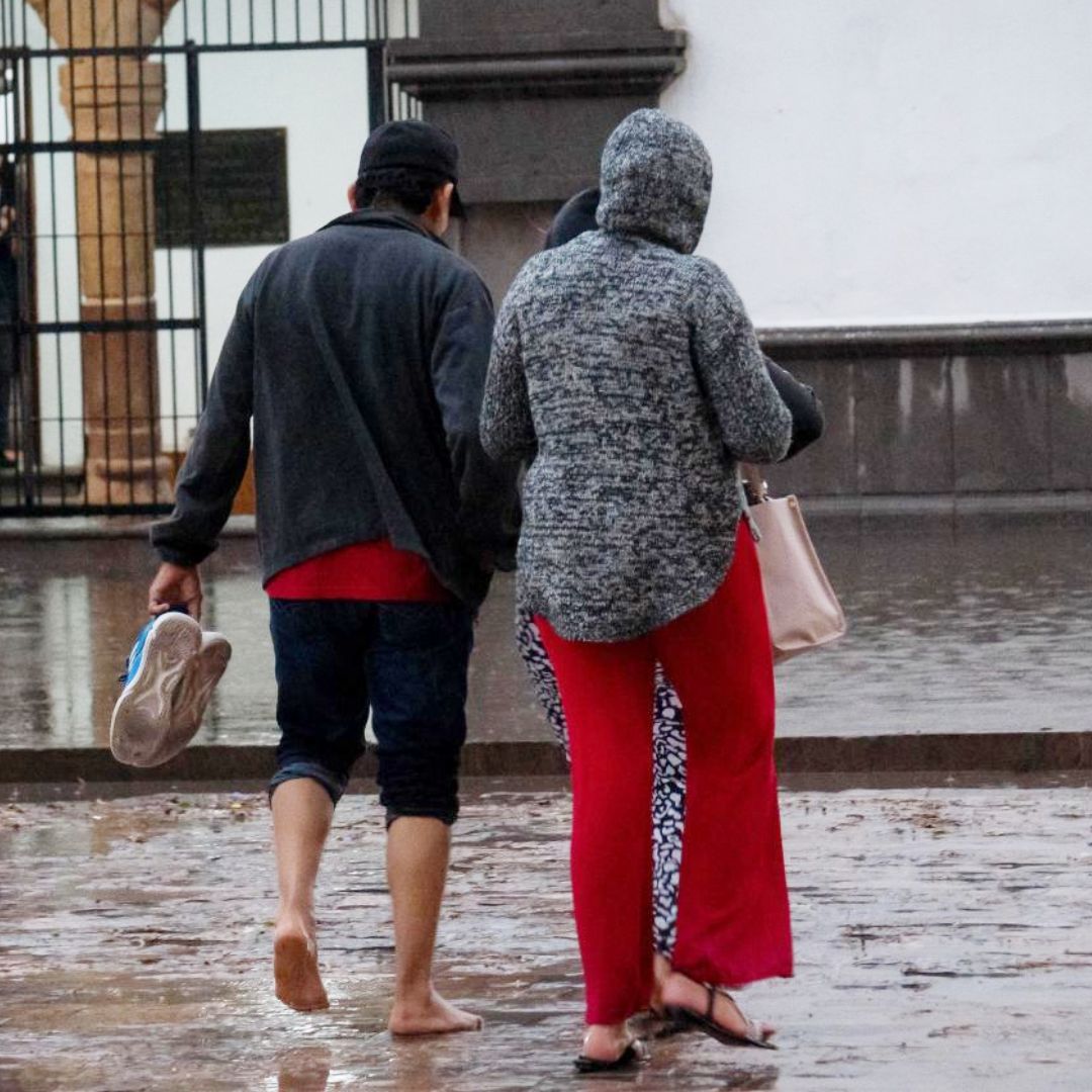 Dos personas caminan por una calle inundada en Tlaxcala